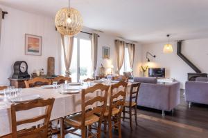 a dining room and living room with a table and chairs at Villa de la Salmonière - Maison avec piscine et jardin clos in La Roche-Blanche