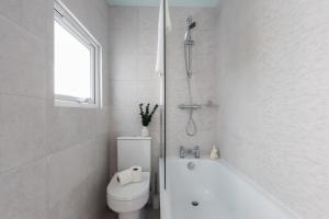 カーディフにあるSanjo Suite - Sleek 2BR Home with Parking & WIFIのトイレと浴槽を備えた白いバスルーム +12枚の写真