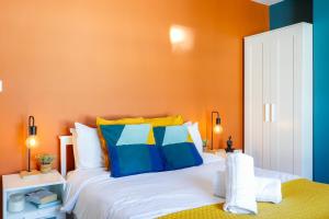 カーディフにあるSanjo Suite - Sleek 2BR Home with Parking & WIFIのベッドルーム1室(青と黄色の枕が備わるベッド1台付)