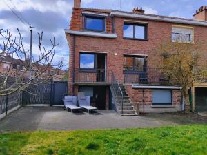 a brick house with two chairs and a staircase at Amazing house 4 bedrooms parking close to Lille in Saint-André-lez-Lille