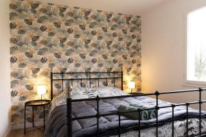 a bedroom with a black bed with a wall at Villa de la Salmonière - Maison avec piscine et jardin clos in La Roche-Blanche +27 photos