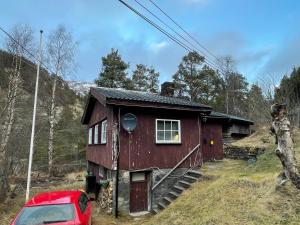 a small house with a red car parked in front of it at Detached cozy house in Lom