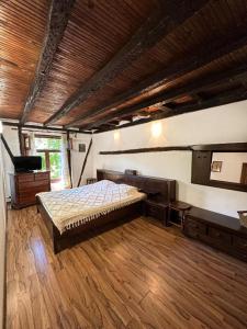a bedroom with a large bed and a piano at Hadjigabarevata Kashta in Dalbok-Dol