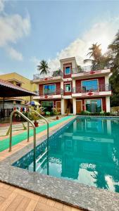 una casa con piscina di fronte a un edificio di Coral Cove Resort, Nagaon a Nagaon