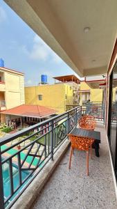 balcone con panchina e vista sulla piscina di Coral Cove Resort, Nagaon a Nagaon