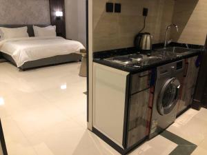 a kitchen with a washing machine next to a bed at شقق ثري ستار للشقق المخدومة 4 in Riyadh
