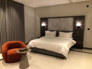 a hotel room with a bed and a chair at شقق ثري ستار للشقق المخدومة 4 in Riyadh