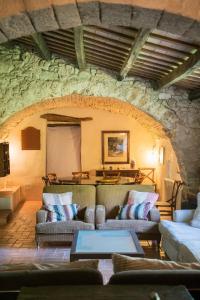 a living room with couches and a stone wall at La Casa de la Llum in Amer