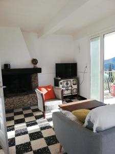 a living room with a couch and a fireplace at Maison vue Panoramique in Vailhan