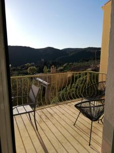 a balcony with chairs and a view of the mountains at Maison vue Panoramique in Vailhan