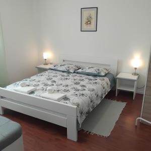 a bed in a room with two tables and two lamps at Castello in Mali Lošinj