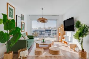 a living room with a green couch and a table at way2sun penthouses - FREE e-bikes & jacuzzi & solarium & PS5 in Gran Alacant +50 photos