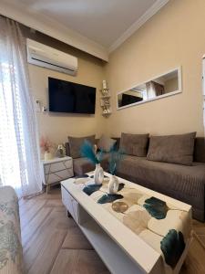 a living room with a couch and a coffee table at Blue Horizon Seaside Studio in Nea Kalikratia
