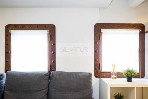 een woonkamer met een bank en 2 spiegels bij Les Moraes By Silastur in Cudillero +8 foto's