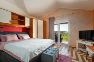 a bedroom with a bed and a television and a balcony at Evan by Briskva in Poreč +23 photos