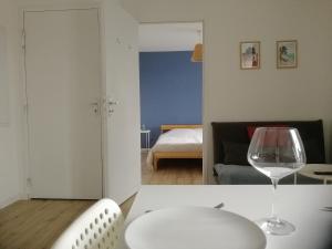 kieliszek wina siedzący na stole w pokoju w obiekcie T2 lumineux - Segré hyper Centre - Wifi - Netflix w mieście Segré +3 zdjęcia