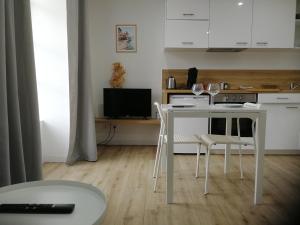 kuchnia z białym stołem i krzesłami w pokoju w obiekcie T2 lumineux - Segré hyper Centre - Wifi - Netflix w mieście Segré