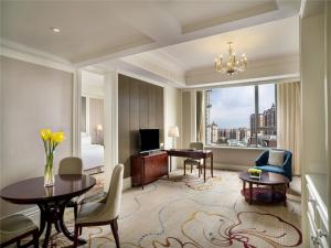 西寧市にあるSofitel Xiningのデスクとベッドルームが備わるホテルルームです。