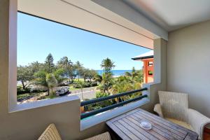 a dining room with a view of the ocean at Kacy's Bargara Beach Motel in Bargara