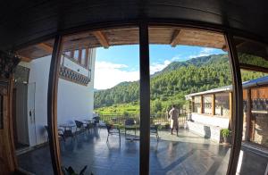 a man standing on a balcony with a view of a mountain at Ananda Resort in Paro