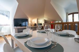 a dining room with a table with plates and wine glasses at La grande Valsassina - Salone in Pasturo