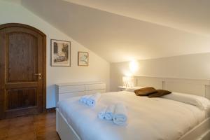 a bedroom with a white bed with towels on it at La grande Valsassina - Salone in Pasturo