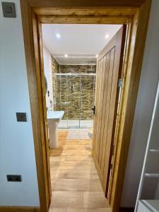 a bathroom with a door leading into a bathroom with a sink at Acorn Lodge Pentewan in St Austell +44 photos