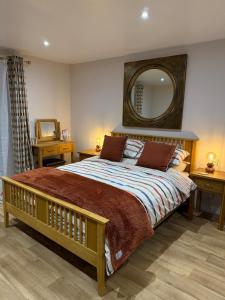 a bedroom with a large bed with a large mirror at Acorn Lodge Pentewan in St Austell