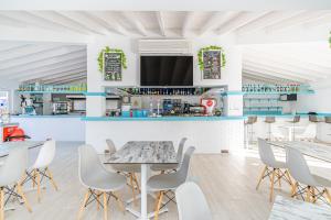 a restaurant with tables and chairs and a counter at Aparthotel Holiday Center in Santa Ponsa