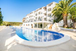 a large swimming pool in front of a building at Aparthotel Holiday Center in Santa Ponsa