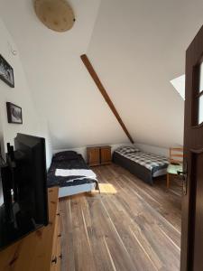 a bedroom with a bed and a flat screen tv at Agroturystyka Traperska Osada in Potasze