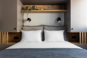 una camera da letto con un letto grande con cuscini bianchi di C&A Studio a Xánthi