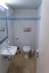 a white bathroom with a sink and a toilet at Apollon Suites in Karistos +34 photos