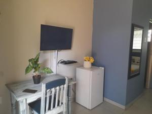 a room with a desk and a tv on the wall at The Rose Guesthouse in Witbank