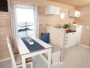 een keuken en eetkamer met een tafel en een raam bij Hausboot Poseidon 1 in Großenbrode