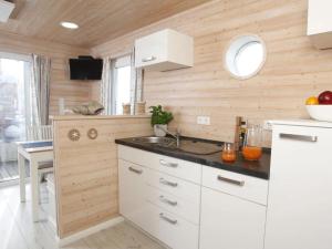 een keuken met witte kasten en een spoelbak bij Hausboot Poseidon 1 in Großenbrode
