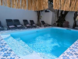 a large swimming pool with chairs in a room at Hôtel Mademoiselle in Juan-les-Pins