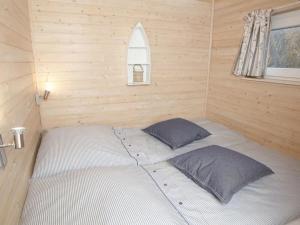 een bed in een houten kamer met twee kussens bij Hausboot Poseidon 1 in Großenbrode +8 foto's