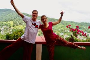 two people standing on a ledge with their arms in the air at Mountain View in Kandy