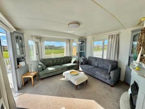 a living room with two couches and a table at Fraunie's Beach House Anderby Creek - Dog friendly in Anderby