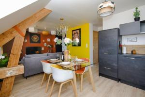 a dining room and living room with a table and chairs at Appartement lumineux et calme avec vue sur la Place Ducale - Hyper centre in Charleville-Mézières +19 photos