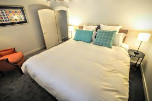 a bedroom with a large white bed with two pillows at Molière ChicSuites in Paris