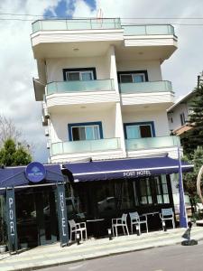 a hotel with a blue awning in front of a building at Port Hotel, Tasucu in Silifke