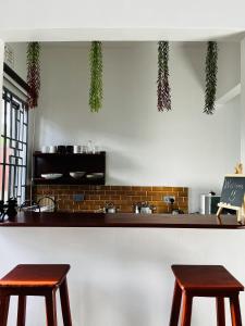 カラトゥにあるA Unique Home Near Ngorongoro Conservation Area Marera Homestayの台所のカウンターに座る木製のスツール2脚