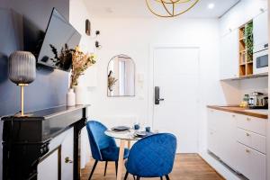 - une cuisine avec deux chaises bleues et une table dans l'établissement OIQIA • Jadéa • Saphir, à Bressuire