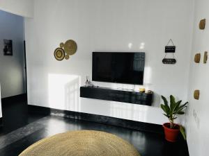 カラトゥにあるA Unique Home Near Ngorongoro Conservation Area Marera Homestayの白い壁のリビングルーム(テレビ付)