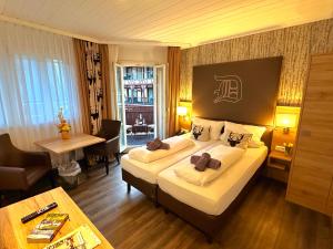 a hotel room with a large bed and a desk at Hotel am Markt Bacharach in Bacharach