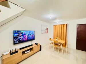 a living room with a television and a table at Zebs cozy cove in Cebu City