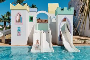 a bride slides down a water slide at a resort at Vibra Blanc Cottage Apartmentos - 3SUP in Sa Caleta +70 photos
