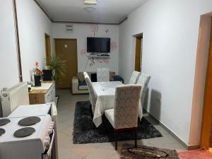 a living room with a table and chairs and a tv at Apartmani Alejna in Sanski most